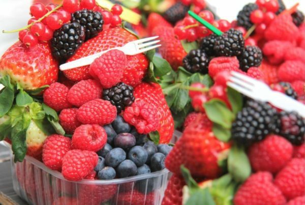 red and black berries in clear glass container